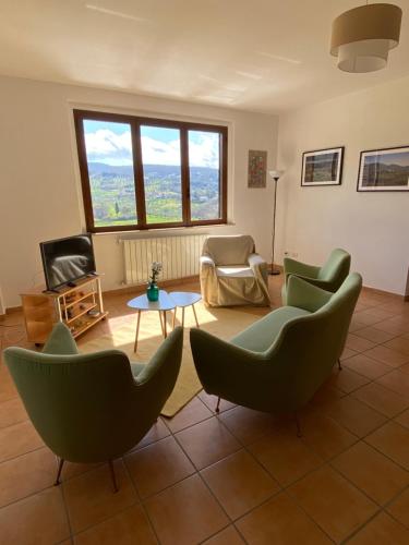 un soggiorno con sedie, tavolo e TV di La Casa di Diana a Montecchio