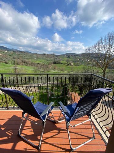 two chairs on a balcony with a view of a golf course at La Casa di Diana in Montecchio