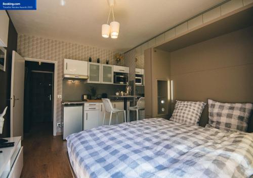 une petite chambre avec un lit et une cuisine dans l'établissement Le Petit Roi - StandingPlace, à Le Chesnay