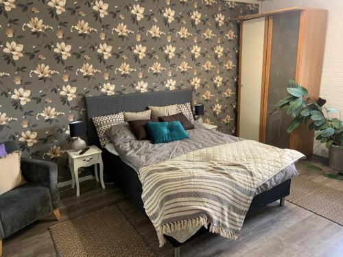 Dormitorio con cama con pared de flores en Alingsgård - B&B, Gårdshotell, Spabad, Bastu, Gym, Padelbana en Löderup