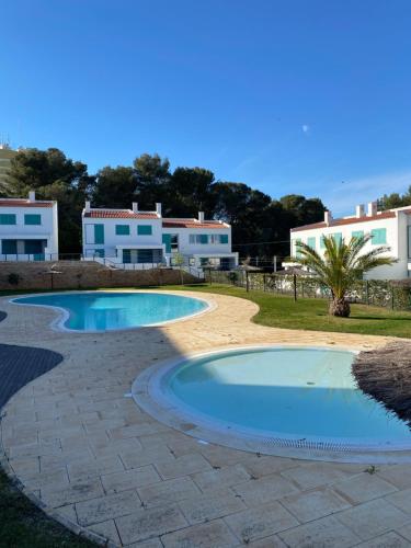 a swimming pool in a yard with buildings in the background at Casa Prainha, Alvor para 10 pessoas in Alvor