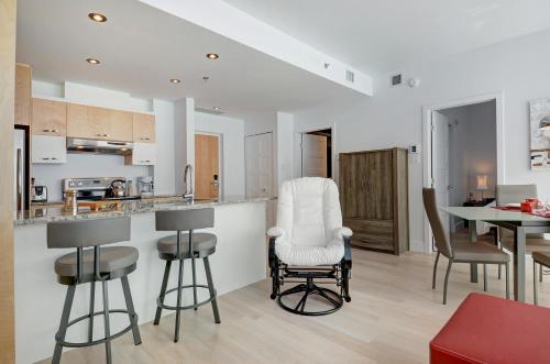 a kitchen and dining room with a counter and chairs at Les Immeubles Charlevoix - Le 760-507 in Quebec City