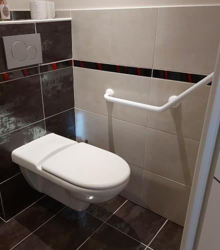 a bathroom with a white toilet in a room at Ome sweet home in Laubressel
