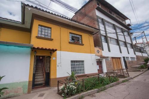 un edificio amarillo y blanco al lado de una calle en CASA HOSPEDAJE EL LABRADOR, en Cusco