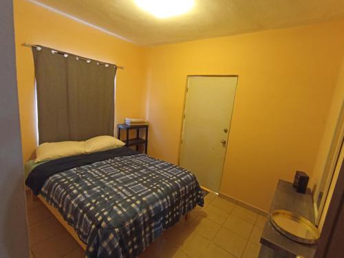 a small bedroom with a bed and a door at Amplio y familiar in Cabo San Lucas