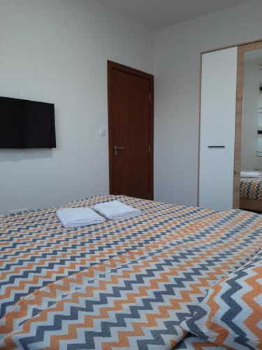 a bedroom with a bed and a flat screen tv at Apartman Milic Pirot-Zapadni Kej 10 in Pirot