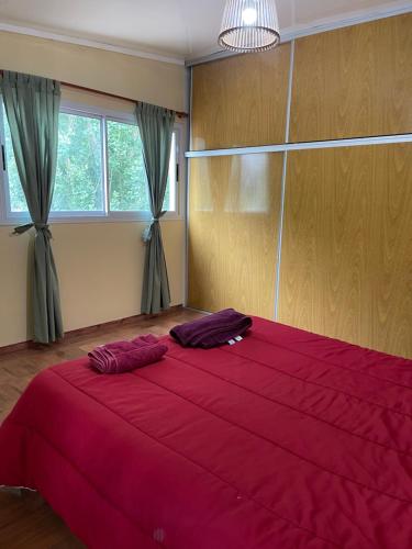 a bedroom with a large red bed with two pillows on it at PHouse in Las Heras