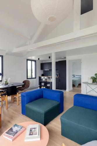 un salon avec un canapé bleu et une table dans l'établissement Le Duplex de Maison Passage, à La Trinité-sur-Mer