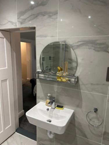a bathroom with a sink and a mirror at 4 bed private home in Colchester in Colchester