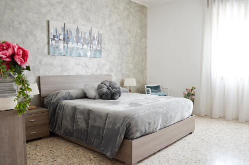 um quarto com uma cama grande com um arranjo de flores em Appartamento Ciclamino em Mestre