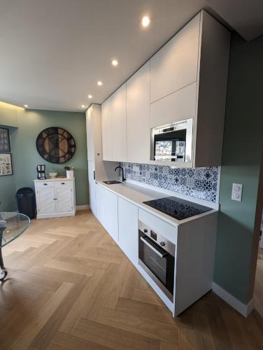 une cuisine avec des armoires blanches et un four à plaques de cuisson dans l'établissement Lovely Refurbished Apartment, à Nice