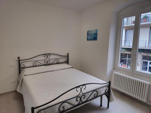 a bed in a white room with a window at Casa Anelita in La Spezia