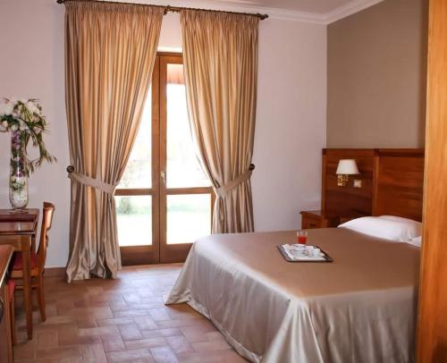 a bedroom with a bed and a large window at Grand Hotel Vigna Nocelli in Lucera