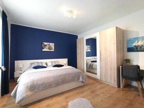 um quarto com uma cama grande e paredes azuis em Apartment Dora em Zadar