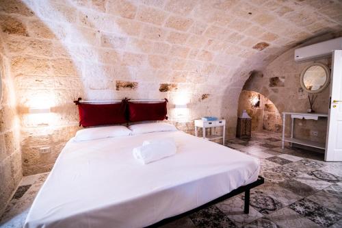 - une chambre avec un grand lit dans un mur en pierre dans l'établissement Le Volte Di San Leonardo, à Monopoli