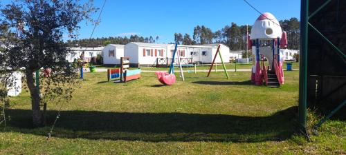 a park with a playground with a slide at Bungalows Land'shause in Pataias