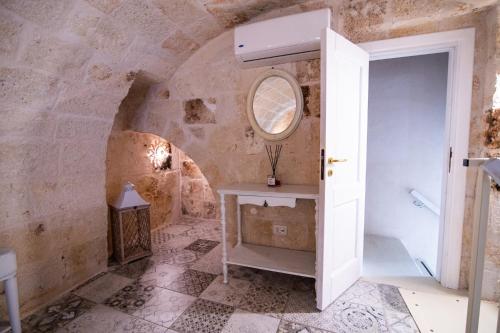 Cette chambre dispose d'une porte, d'une table et d'un miroir. dans l'établissement Le Volte Di San Leonardo, à Monopoli