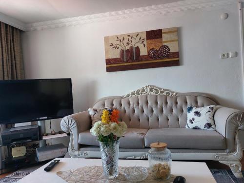 sala de estar con sofá y TV en Tarabya Family Suıt Boğaziçi, en Estambul