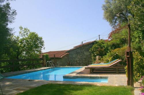 uma piscina com um banco num quintal em Casa Da Rocha em Caldelas