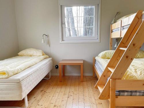 1 dormitorio con 2 literas y ventana en Holiday home GRIMSTORP en Grimstorp