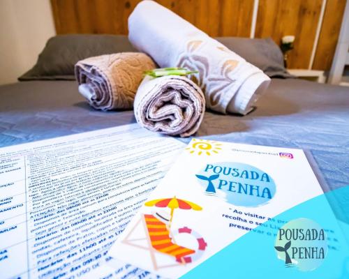 una mesa con algunos papeles y toallas en una cama en Pousada Penha 1 Beto Carrero, en Penha