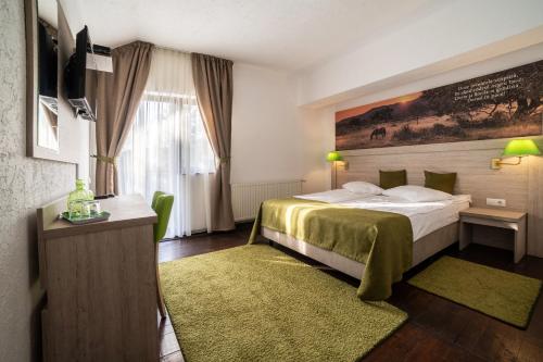 ダネシュにあるHanul din Padureのベッドと窓のあるホテルの部屋