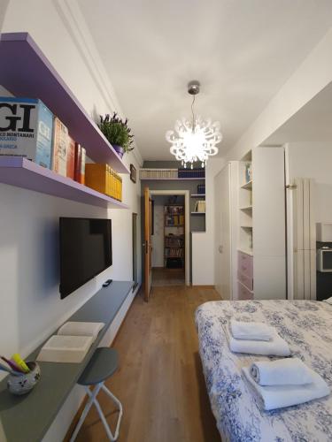 a bedroom with a bed and a tv on a wall at Alma Vacation Apartment in the centre, big terrace in Milan