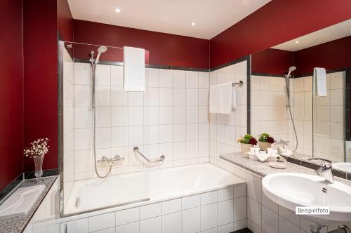 La salle de bains est pourvue d'une baignoire et d'un lavabo. dans l'établissement Angel's - das hotel am fruchtmarkt, à Saint-Wendel