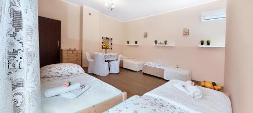 a room with two beds and two tables at Apartamenty Górki Małe in Tuszyn