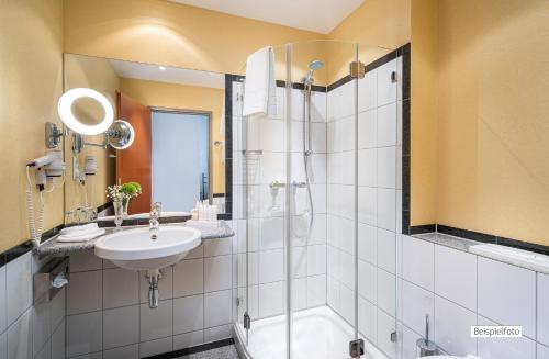 a bathroom with a sink and a shower at Angel's - das hotel am fruchtmarkt in Sankt Wendel