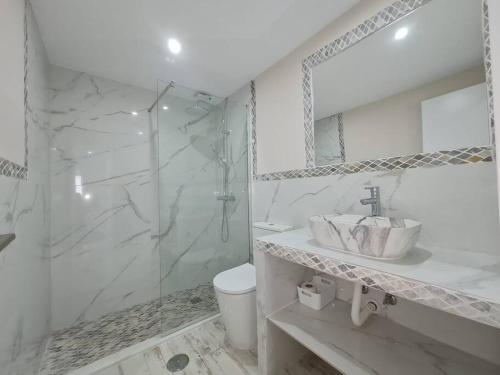 a white bathroom with a sink and a shower at Luxury apartment in Zahara beach in Zahara de los Atunes