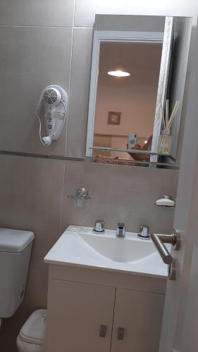 uma casa de banho com um lavatório, um WC e um espelho. em Monoambiente céntrico La Plata em La Plata