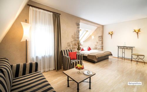 a living room with a couch and a bed at Angel's - das hotel am fruchtmarkt in Sankt Wendel