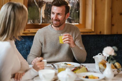 um homem e uma mulher sentados numa mesa com um copo de sumo em Hotel Seespitz em Ischgl