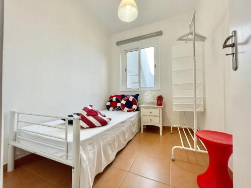 1 dormitorio con 1 cama blanca y 1 silla roja en FUZETA MARÉ BAIXA RIA VIEW by Ethnic Ocean, en Fuseta