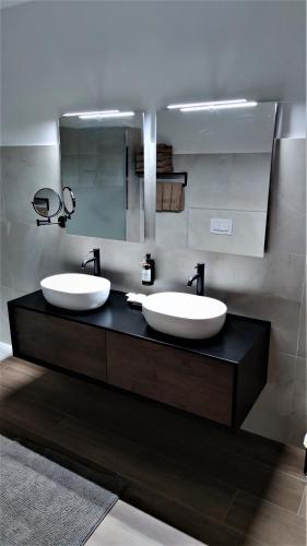 a bathroom with two sinks and a mirror at Hotel Emiliana in Villadossola