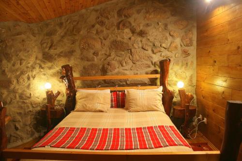 a bedroom with a bed with a stone wall at Casa Da Rocha in Caldelas