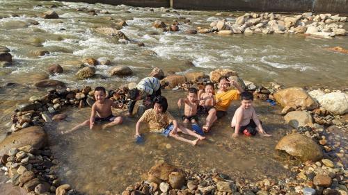 a group of people sitting in the water in a river at Sapa Riverside Homestay in Sa Pa