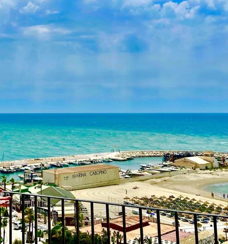 a view of a beach with a marina and the ocean at ESPECTACULAR Hogar en la playa MARBELLA in Marbella