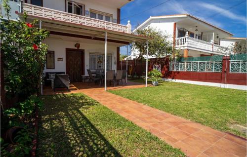 a house with a patio and a yard at Beautiful Home In Torre De Benagalbón in Torre de Benagalbón