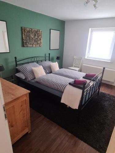 ein großes Bett in einem Zimmer mit grünen Wänden in der Unterkunft Ferienwohnung Bohn in Kappel-Grafenhausen