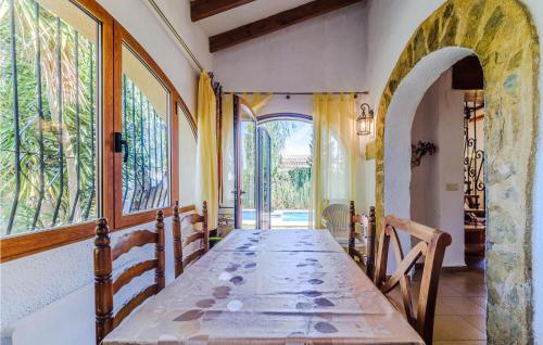 comedor con mesa y algunas ventanas en Stunning Home In Els Poblets With Outdoor Swimming Pool, en Els Poblets