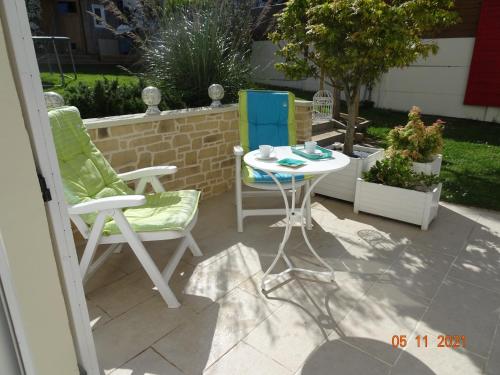 a patio with two chairs and a table on a patio at Ty Mamm Goz in Paimpol
