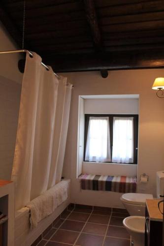 a bathroom with a toilet and a window at Casa do Pinheiro in Alcácer do Sal