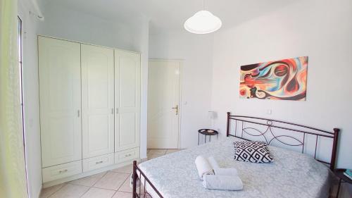 a bedroom with a bed and a painting on the wall at AGIOS LEON Apartment 3 in Agios Leon