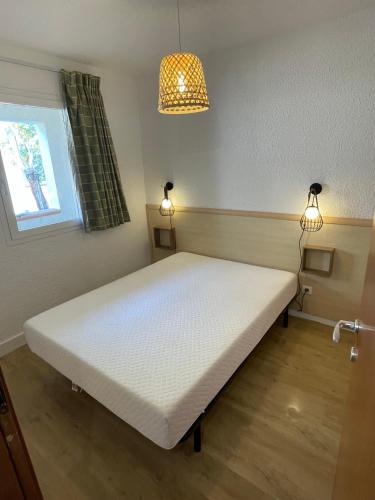 un lit blanc dans une chambre avec une fenêtre dans l'établissement Superbe T2 Sognu di Mare, à Linguizzetta