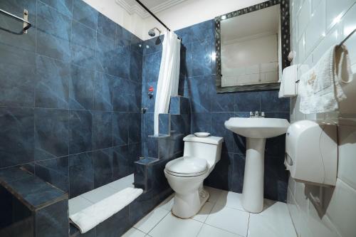 a bathroom with a toilet and a sink at Gran Hotel París in Cuenca