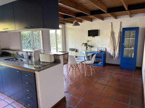 Una cocina con encimera y mesa con sillas. en Fisherton Alquiler Temporario, en Rosario