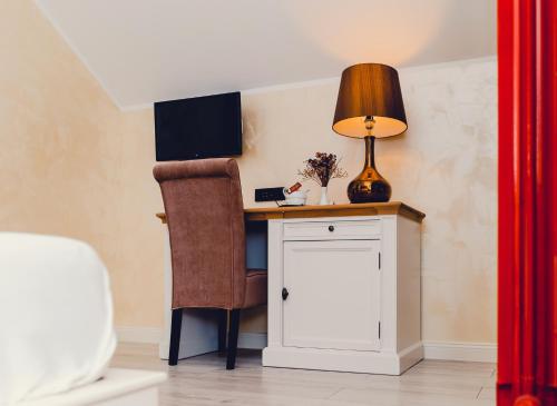 a desk with a chair and a lamp on it at Casa Del Sole in Alba Iulia