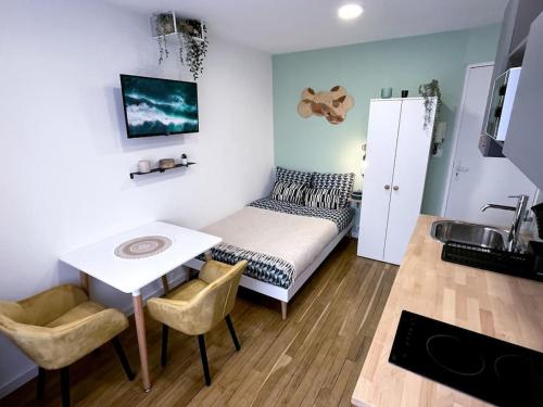 une petite pièce avec un lit, une table et des chaises dans l'établissement Le Central • Hyper Centre • Proche Gare • Fibre, à Châteauroux